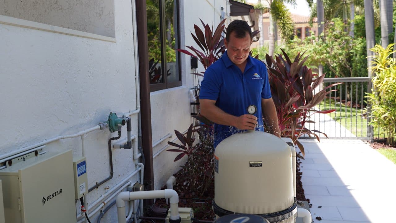 Technician releasing pool filter pressure at the relief valve during an inspection