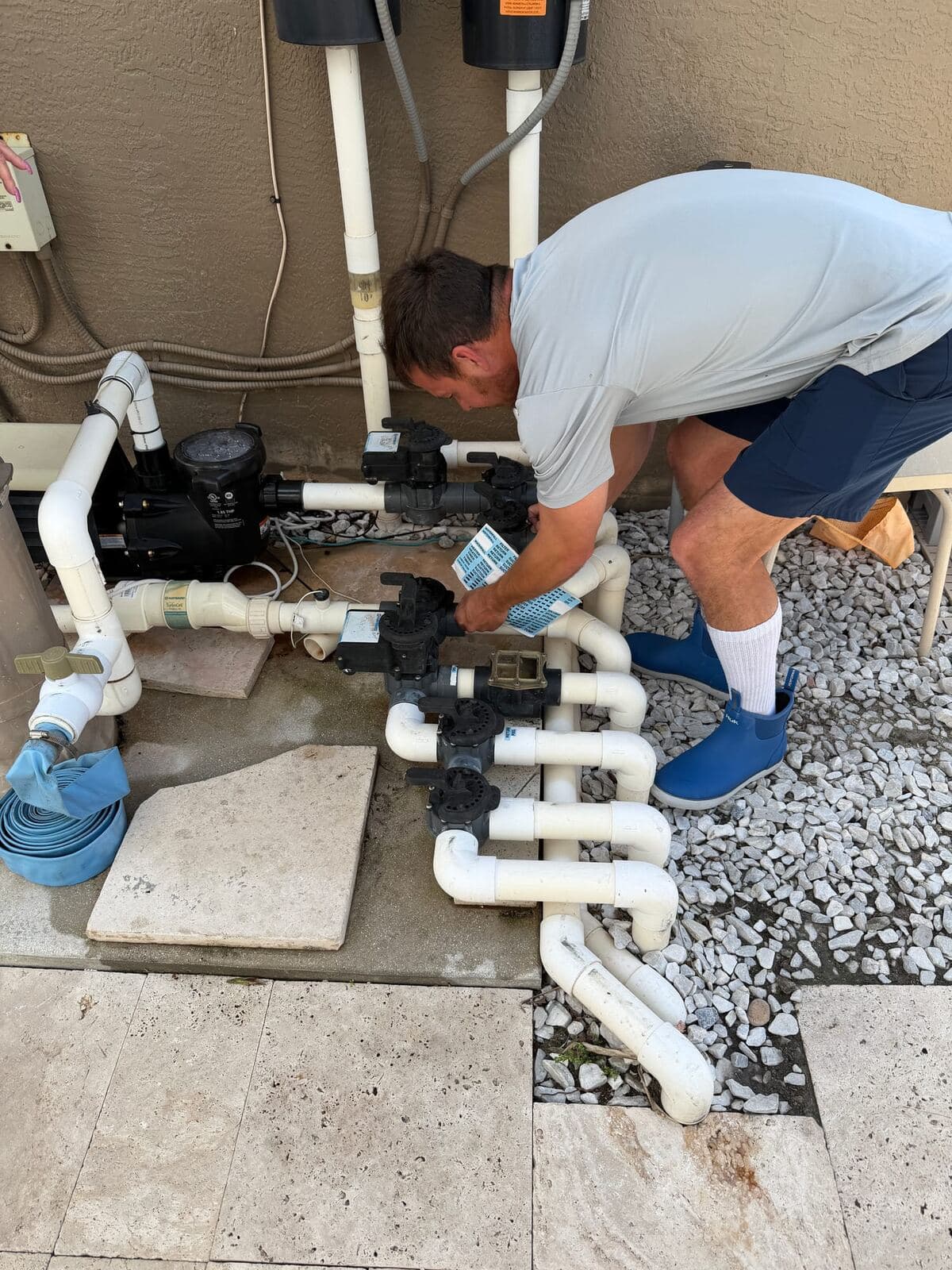 Florida's Best Pools technician working on a South Florida pool equipment pad with pump, filter, and heater