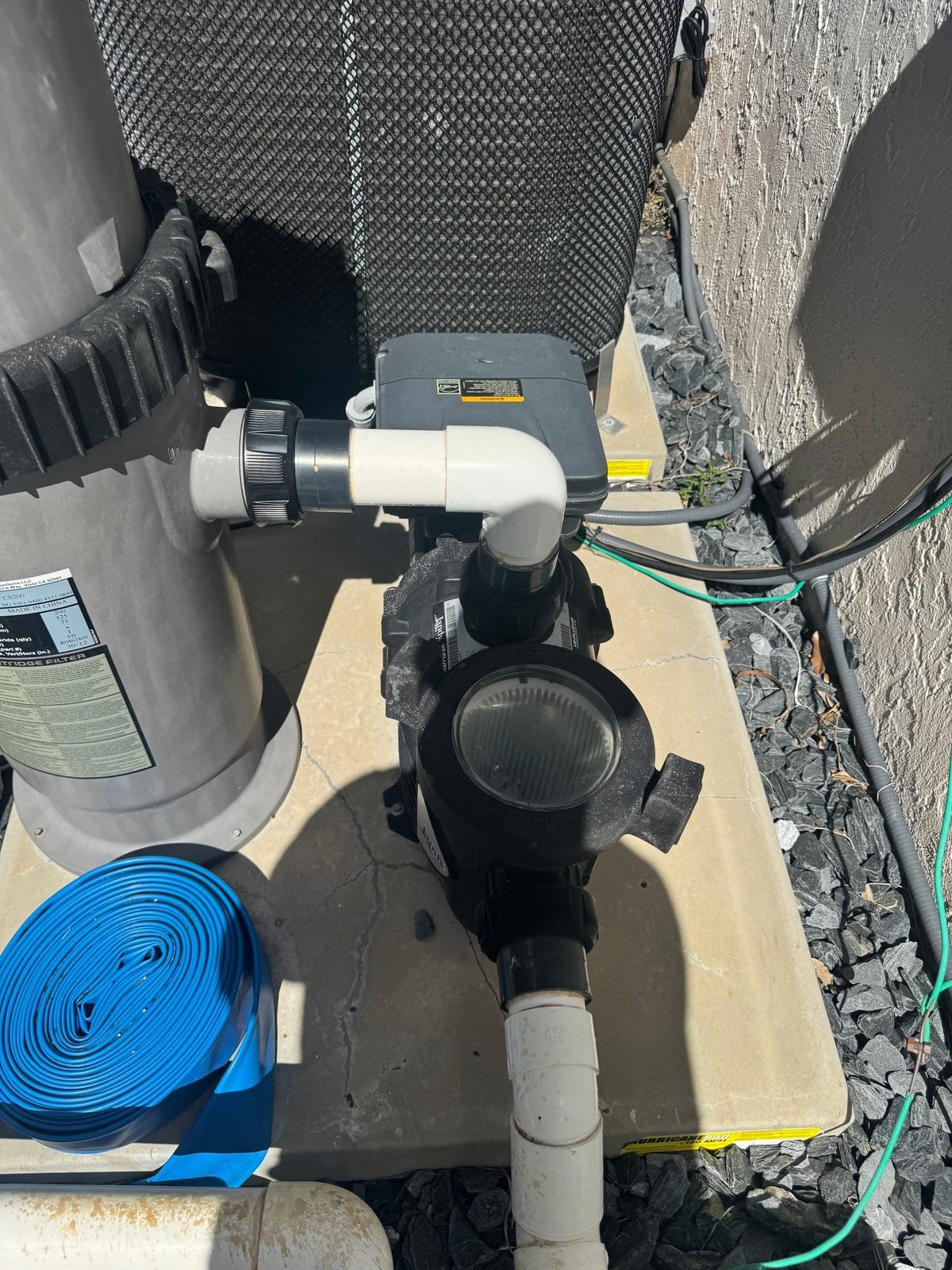Close-up of a residential pool pump and cartridge filter on a South Florida equipment pad — the parts and configuration the repair-vs-replace decision actually turns on
