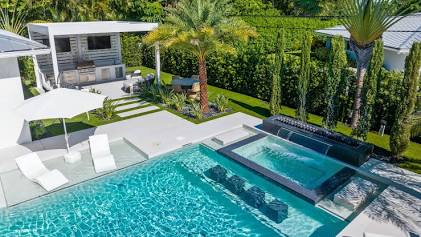 Estate-tier residential pool with hospitality-borrowed design — the middle-tier build where dual-sanitizer redundancy, commercial automation, proper skimmer count, and commercial deck drainage actually pay back