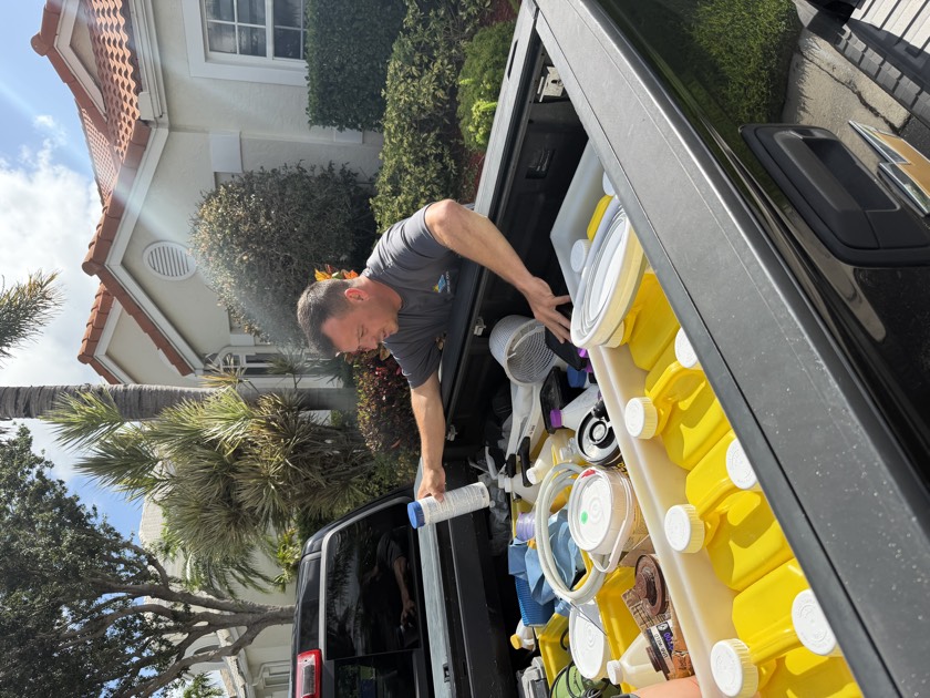 Florida's Best Pools service truck and route technician on a South Florida weekly pool route — the team that runs quarterly calibrated CYA tests to catch stabilizer creep before it locks the chlorine